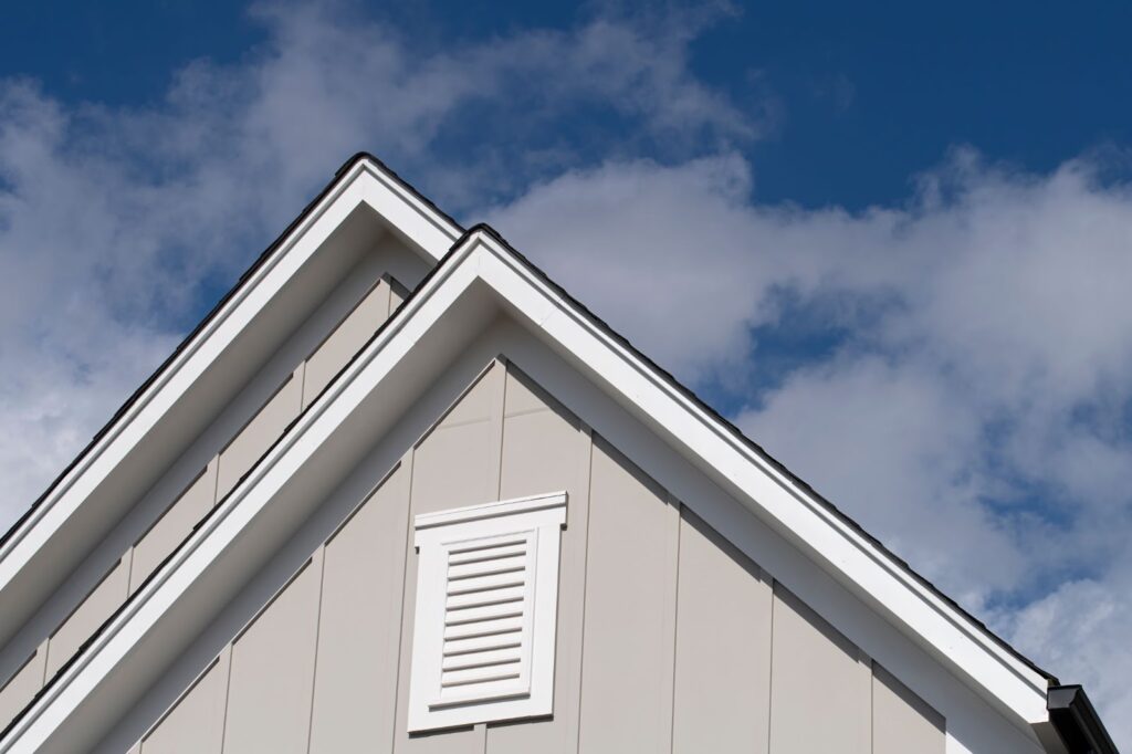 A white house with blue sky and white shutters. Perfect for siding companies and various home siding options